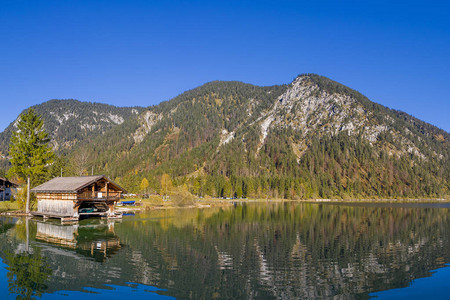 深沉在清蓝湖平原中的水上小屋见奥图片