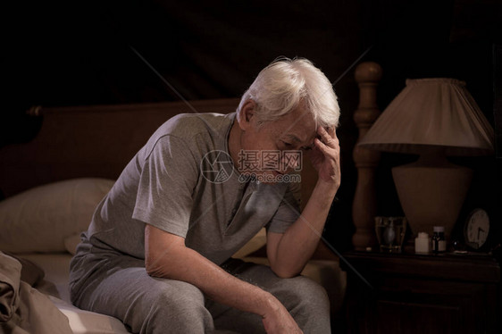 感压的老年人坐在床上睡不着失图片
