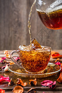 茶杯中清亮的茶杯用干鲜花倒在图片
