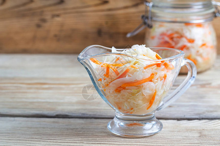 木桌上玻璃盘中的发酵卷心菜健康饮食图片