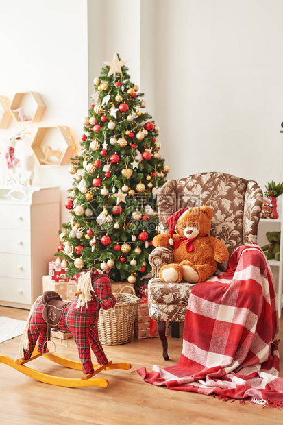 儿童卧室的圣诞内饰儿童游戏室的装饰和树托儿所里的圣诞节圣诞树背景上的摇马图片