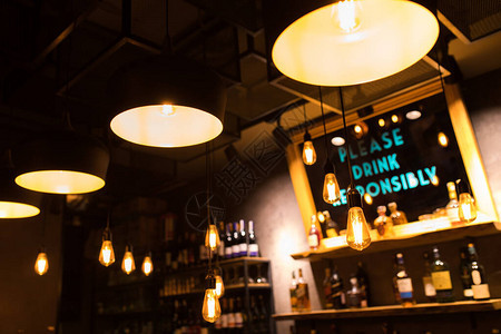 咖啡厅的老式豪华室内照明装饰老式灯泡餐厅酒吧照明室内设计酒精饮料瓶前酒背景图片