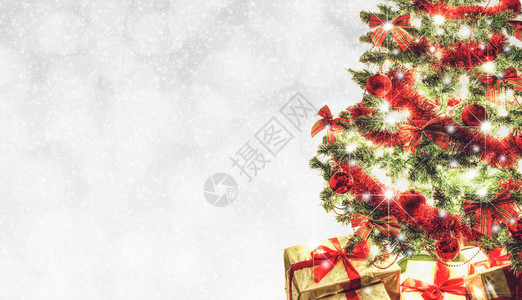 美丽的节日问候卡在bokeh灯光上的圣诞树和带复制空图片