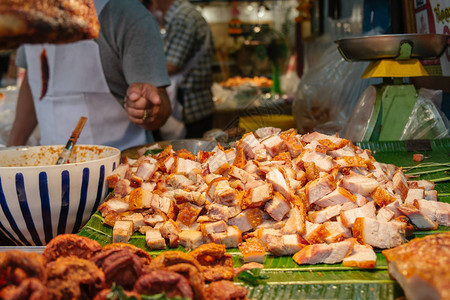 在泰国曼谷的一家当地街道食品店出售香蕉叶上的脆猪肉crospy图片