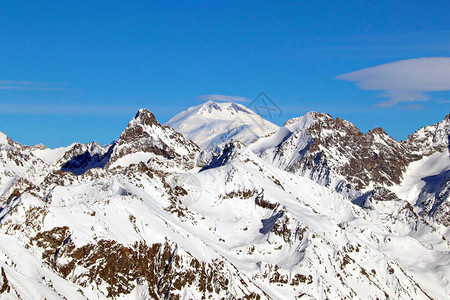 在云彩蓝天的雪山峰顶图片