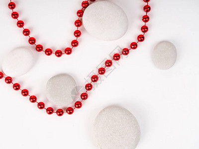 白色海石和它们之间的红色珠子在白色背景上基材质地红色美丽的亮珠图片