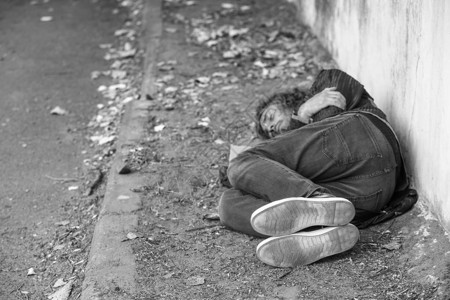 贫穷无家可归者在户外露地睡觉的黑背景图片