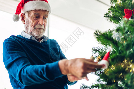 老人在庆祝新年前夜时放松装饰圣诞树图片