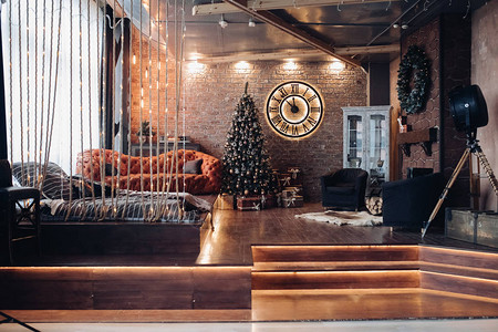 带罗马数字的大钟现代沙发地板上的床两把扶手椅和圣诞装饰品背景图片