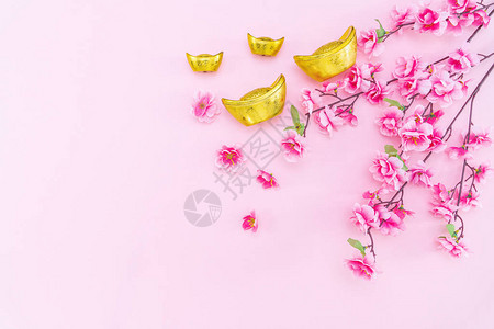 平躺农历金币和粉红色背景中的花朵图片