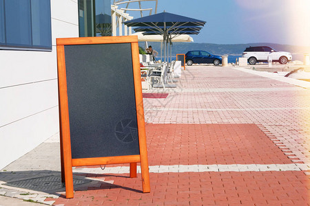 黑板菜单的黑色是信息或广告的颜色Mockup正站在海边餐厅背景图片