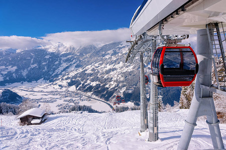奥地利迈尔霍芬蒂罗尔州齐勒塔尔竞技场滑雪胜地的红色缆车在冬季阿尔卑斯山背景图片