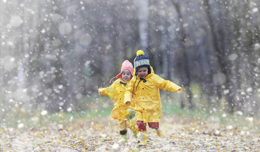 蹒跚学步的孩子们在秋天的公园里散步秋林初霜雪孩子们在公园背景图片