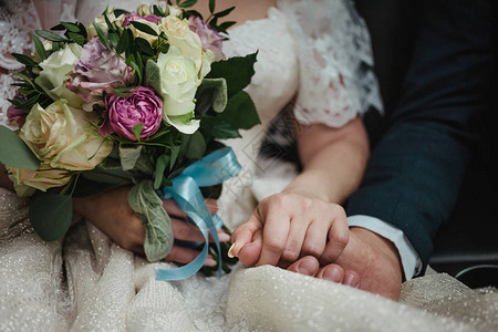 新娘和新郎手上的结婚花束夫妻坐着握手的婚纱白裙图片