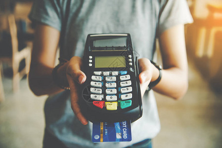手持信用卡刷机付款的特写在线支付图片