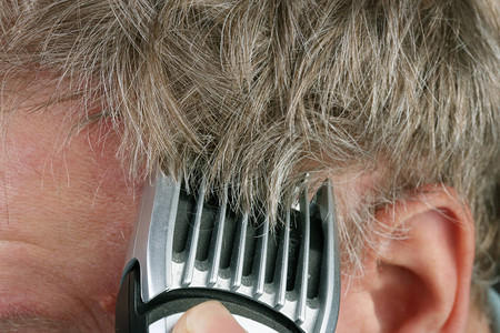 年长老人用电动剪发机将头部剃头发工作室大型自然色图片