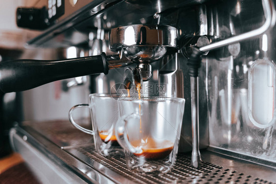 芬芳的浓缩咖啡从咖啡机流入杯子用专业的咖啡设备图片
