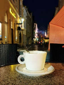秋天在塔林老城晚上街边咖啡馆在城市浅粉色伞雨季街边灯光模糊城市人天气景观背景图片