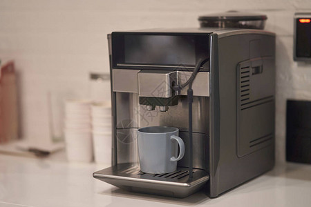 带杯子的现代咖啡机煮咖啡图片