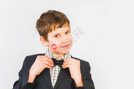 脸上有吻痕的男孩拿着蝴蝶结领一个印着口红图片