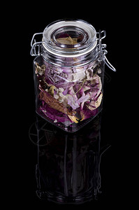 在一个罐子中的干装饰花瓣在黑图片