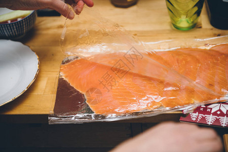 商用厨房妇女用手打开鲑鱼红生物有机生肉鲜背景