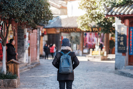 年轻女子旅行者在丽江古城广场街旅行图片