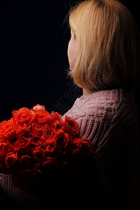 巴洛克风格的女孩肖像模型对观察者来说是一个背影手里拿着一大束花图片