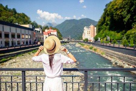 欧洲城市山河堤岸上戴帽子的妇女背影图片