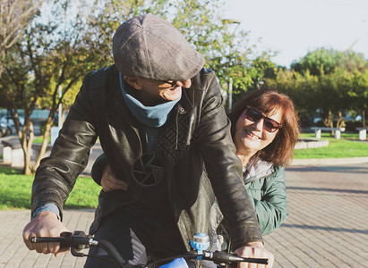 退休夫妇享受空闲时间骑自行车散步中年夫妇骑自行车一起玩乐和微笑温暖图片