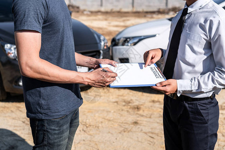 保险代理人和客户在事故碰撞交通事故和保险概念后评估谈判检查和签署报图片