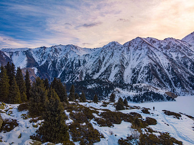 一位旅行者在冬季的山湖上与黎明相会早上冬天山区风景大阿拉木图湖背景图片