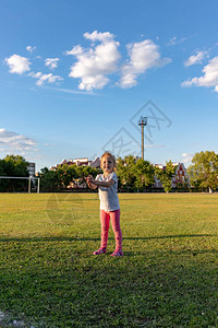 一个小孩在体育场参加体育运动挂在单杠图片