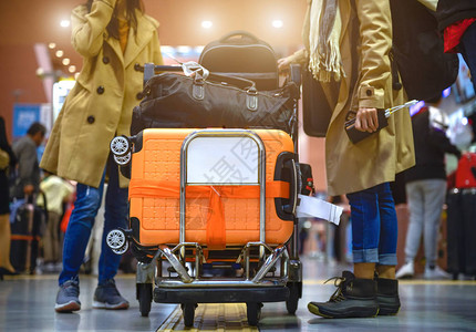 机场推车许多行李由女旅客在机场提手的推车中携带背景