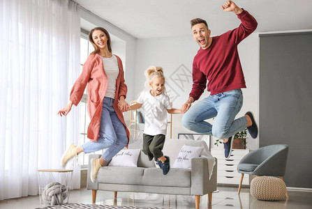 在家跳跃的愉快的家庭图片