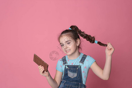 快乐的笑女孩在欢乐的心情中吃甜食巧克力在明亮图片