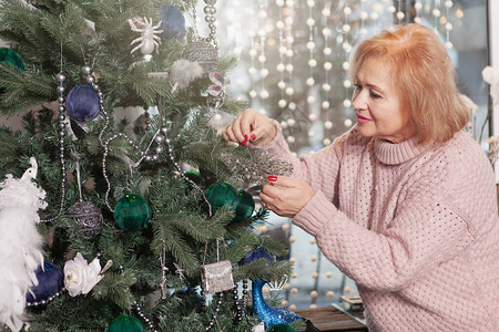 在家装饰圣诞树的老妇人图片