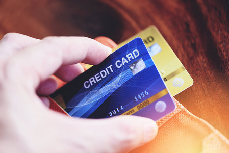 商人手持信用卡并在木质背景下用于网上购物人们支付技术钱网上支付图片