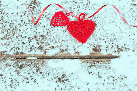 在雪覆盖的粗木板上用带丝划红心切红心图片