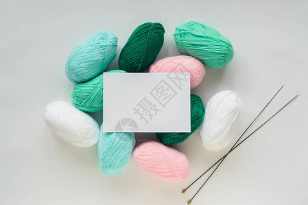 针织丙烯酸软柔和彩色羊毛纱线束堆和白色背景上的针白纸图片