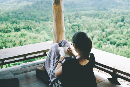 女人正在写白色的小备忘录笔记本上图片