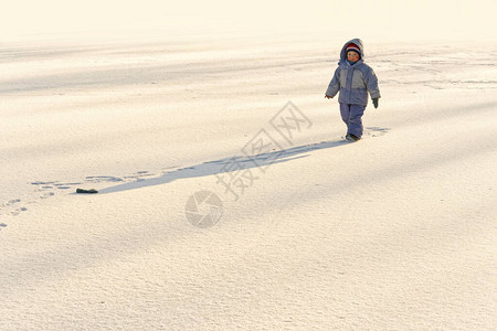 冬天的寂寞小男孩在雪中的冰上图片