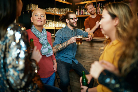 一群朋友在酒吧喝啤酒聊天和玩得开图片