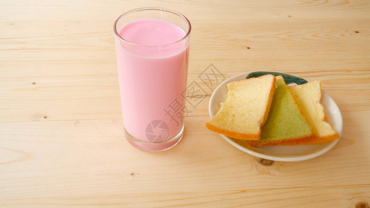 一杯带黄油面包的粉红牛奶图片
