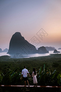 日出时的攀牙湾一对夫妇在泰国攀牙府的沙图片