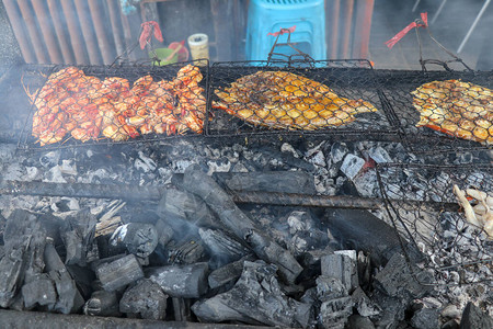 鱼烧烤在上烹饪烧烤海鲜用燃烧的煤烧烤在金巴兰热带巴厘岛的鱼市场上图片