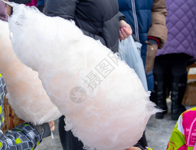在节日或狂欢节上从街头销售商那里收取购买收回糖棉花糖图片