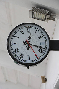 在车站有黑色时针和分针和红色秒针的挂钟图片