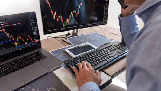 商人经纪人分析财务数据图表和屏幕上的报告以用于股票市场交易图图片