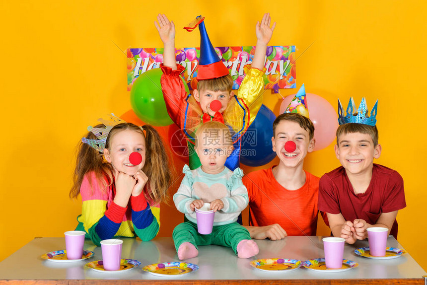 五个孩子坐在节日桌前和一个小丑一起穿图片